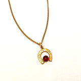 Horseshoe pendant with red stone